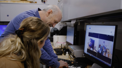 Ken Aigen working with a student at a computer and mini keyboard. 