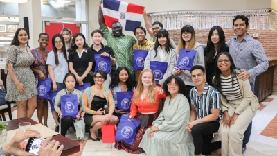 A group of students taking a photo together holding gift bags during their Spanish class at Pontificia Universidad Católica Madre y Maestra, in Santiago, Dominican Republic.