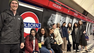 A group of students stands and sits in the Holborn tube station in London