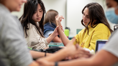 Students doing a physical therapy exercise involving the forearm and wrists.