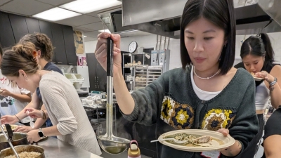 Students labeling soup out of a pot.