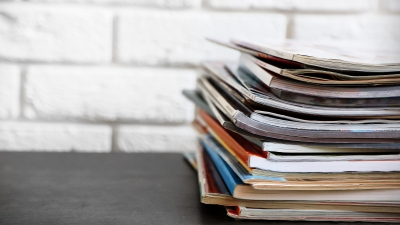 A stack of publications sits on a desk.