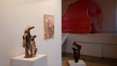 Two abstract sculptures and a painting on display in a gallery.