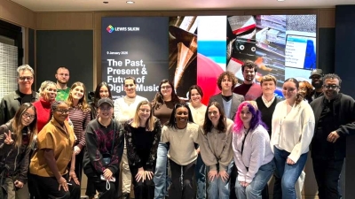 Students and faculty stand together for a group photo inside the Lewis Silkin office after a guest lecture, smiling toward the camera. 