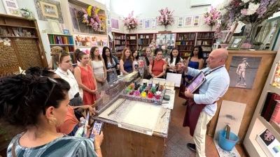 Students watch a painting demonstration in a store in Florence