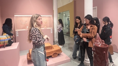 VAA alum Kellie Riggs ('20) speaks with students in an exhibition space.