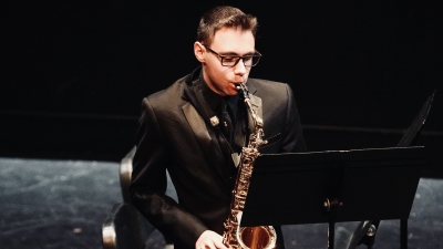 Student playing the saxaphone on stage