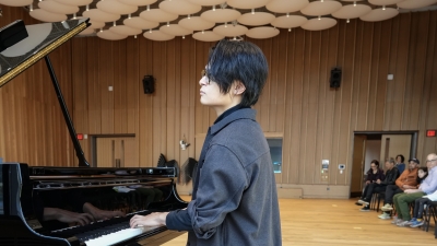 Student performing on piano in Pauslon Center before live audience