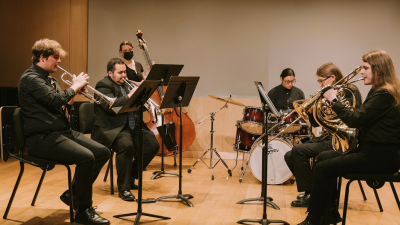 Group of students practicing brass, bass and drums in studio