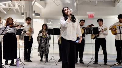 Mariachi instrumental performers and one singer in the center