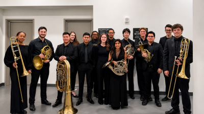 Brass Studies students posing for group photo before concert. Dressed in black and holding instruments.