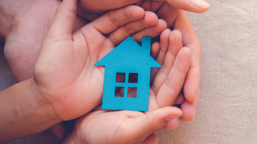 picture of hands and a paper doll house