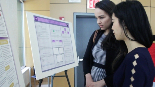 faculty and student looking at poser