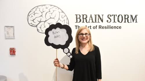 Women with sign in front of gallery text. 