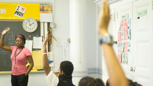 Student raising hand in classroom