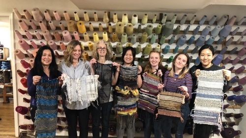 Students with weaving in front of wall of thread.