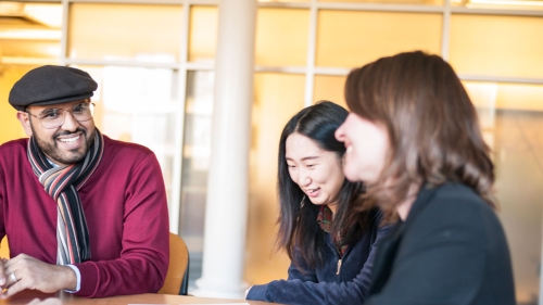Two international students speaking with an adviser