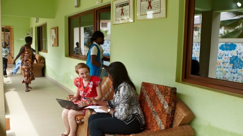 Two women sitting on a couch talking