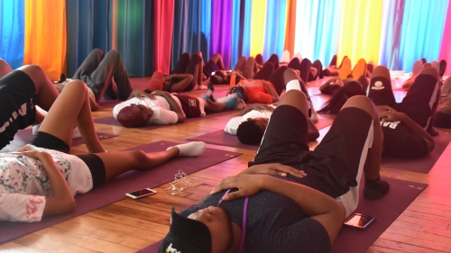 A group of students meditate on their yoga mats. 