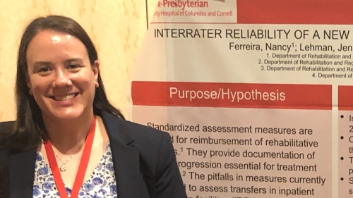 Jennifer Rubinacci Lehman standing in front of a poster wearing a conference badge.