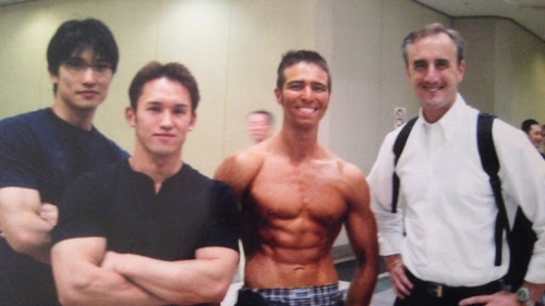Arthur posing with three other men. He looks very muscular.