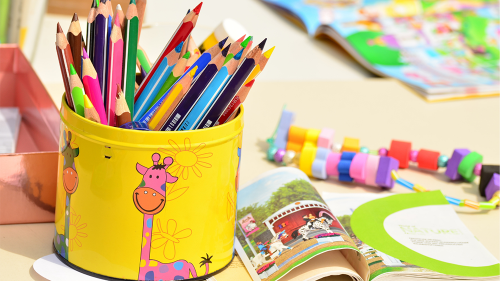 Color pencils and children's book to represent kindergarten class