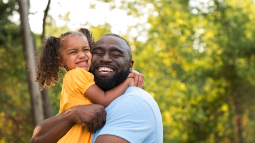 Father hugs daughter happily