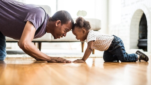Adult male and child look eye-to-eye 