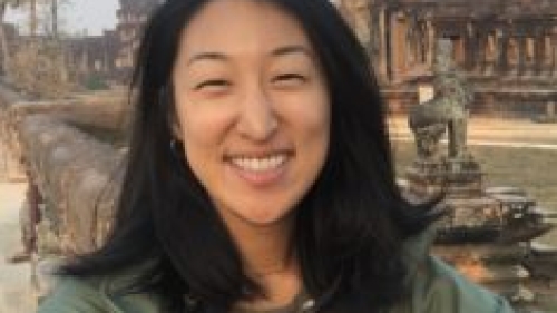 woman smiling on front of statue
