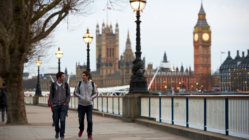 An image of NYU student walking down The Queen's Walk by River Thames with Big Ben in the background. 