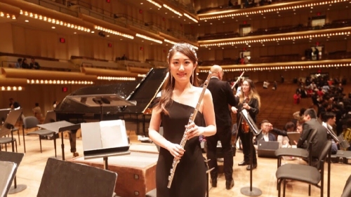 woman on stage holding flute 