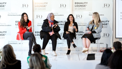 Four women sit in front of an audience at the Equality Lounge.