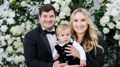 Talia Bender with husband and son standing in front of flowering tree