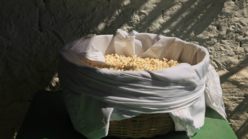 Popcorn in a tub with cloth on green strand.