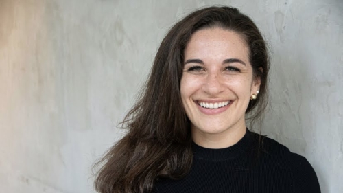 Lindsay smiles at the camera wearing a black sweater.