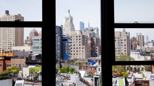An photo taken from the BFA event space in the Barney Building. It's a view of the East Village in Manhattan broken up by thick back windowpanes.