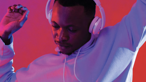 Young man dancing with headphones on cover of paper by Professor Larry Miller