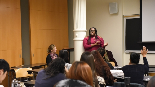 Erika Hardaway, standing next to Heddy Lahmann, addresses a class of students from Steinhardt's international education program. 