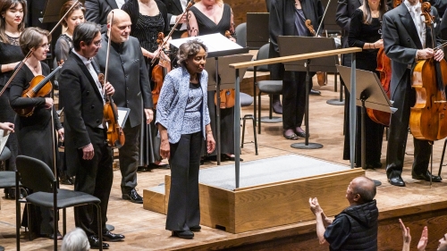 Tania León acknowledges the audience’s applause after the world premiere of her Stride. In the background is the New York Philharmonic.