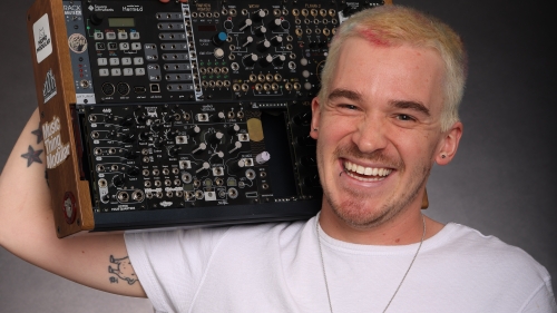 NYU Music Technology alum Travis Fodor holding sound equipment