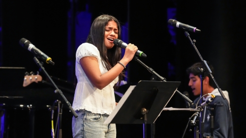 NYU songwriting student singing at microphone