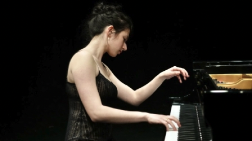 NYU female student gracefully playing piano