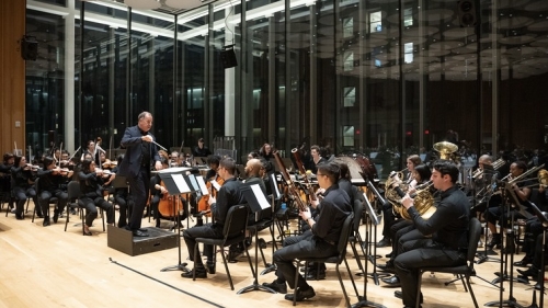 NYU orchestra performing with conductor Ted Sperling