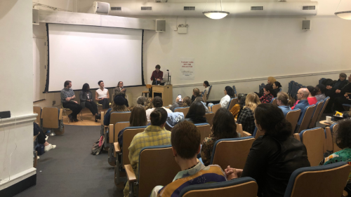 An audience of conference participants watches a roundtable discussion with former director's of NYU's costume studies program.