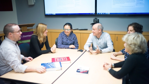 ASH instructors and students sitting around a table in a classroom