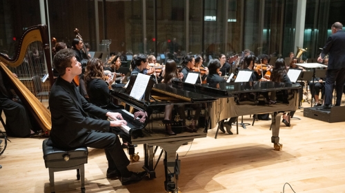 Full orchestra playing with piano prominently in front