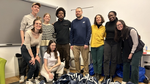 A group of IHDSC affiliated members standing as a group in front of care packages.
