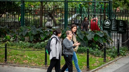 Professor Weinstein walking with 2 female students in Washington Square Park