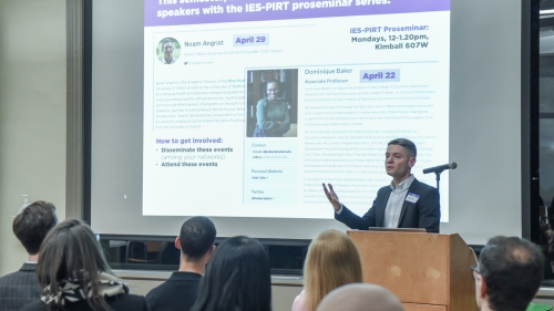 Alejandro J. Ganimian speaking to an audience from a podium in front of a slide that lists information about the Education Policy Group