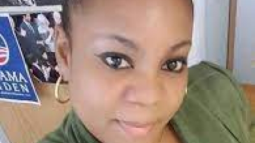 Headshot of Lonice Eversley. Photo feature a woman seated at a desk, wearing a green colored top.